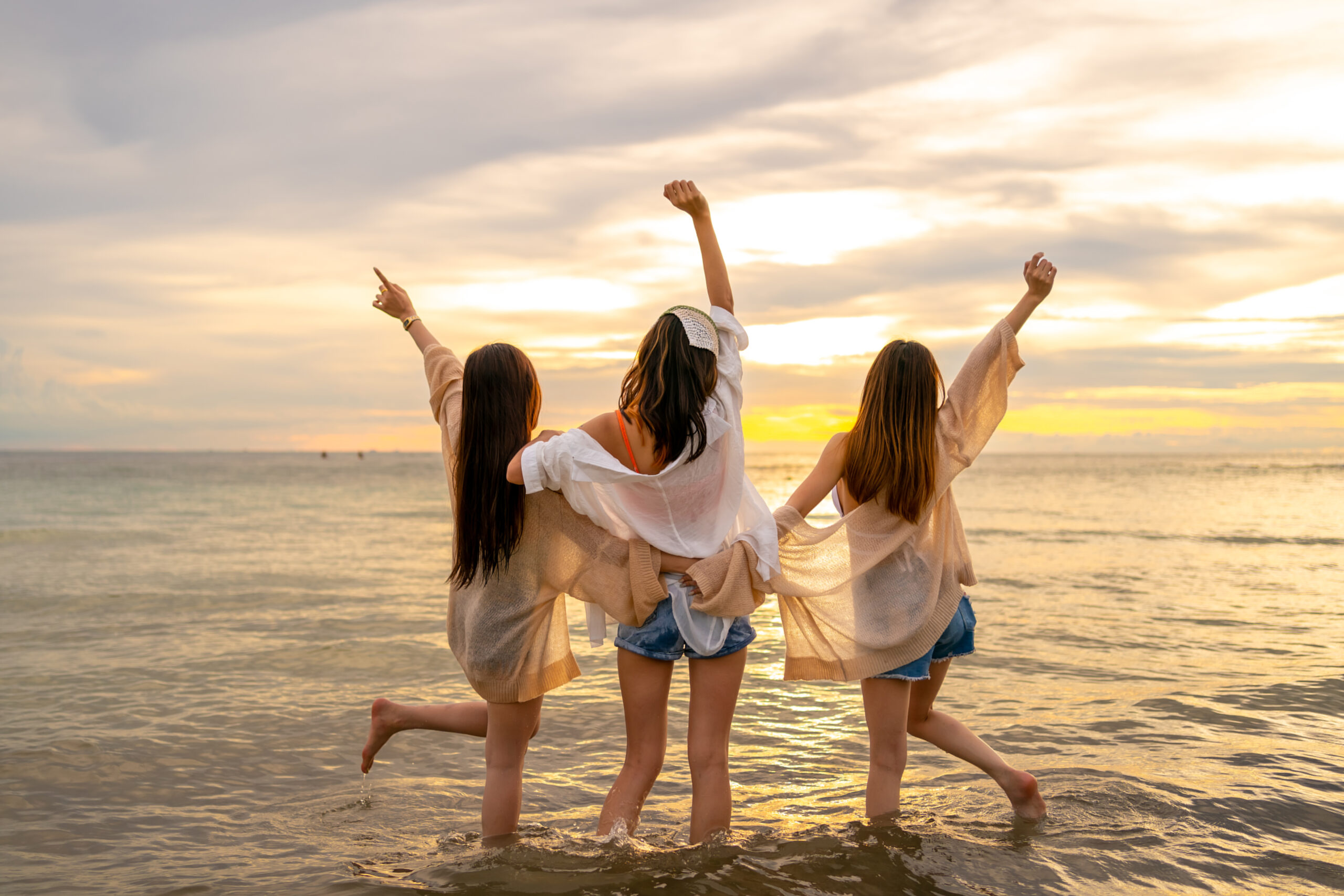 Group of Young Asian woman enjoy and fun outdoor lifestyle travel nature ocean on summer beach holiday vacation. Attractive girl friends walking and playing together at the sea on tropical island.
